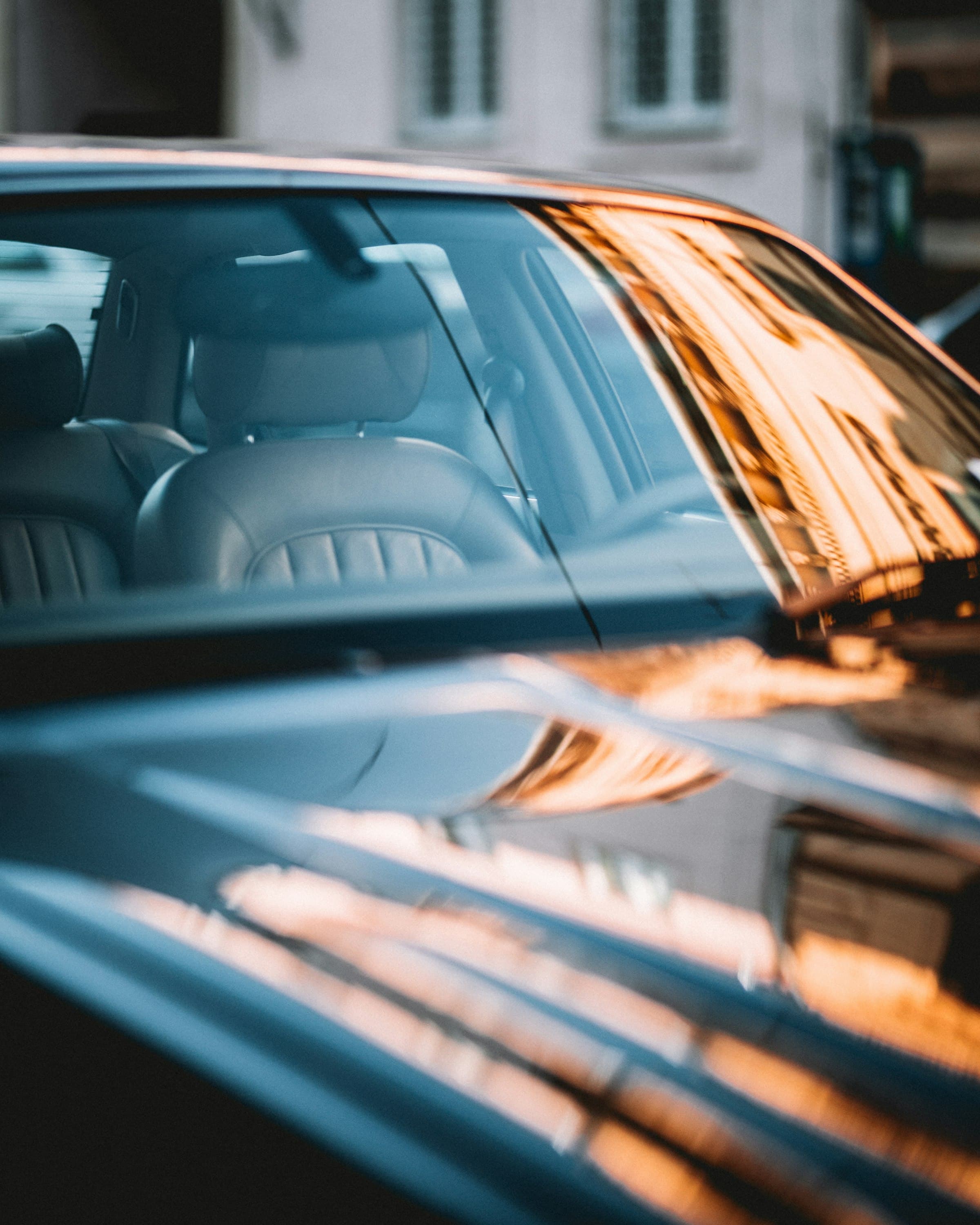 Close-up of a dark car window with reflections